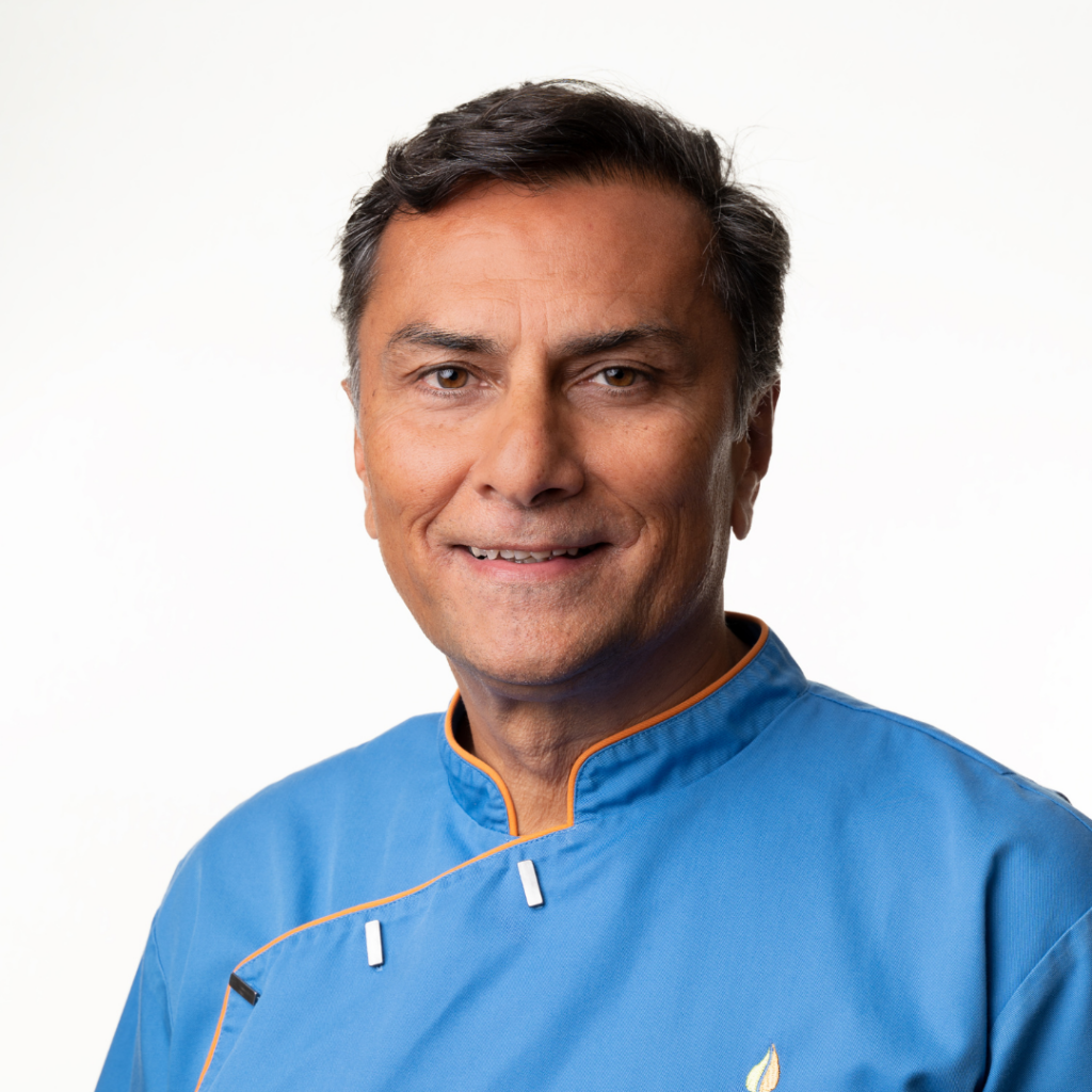 Portrait of a senior clinician at The Health Equation, wearing a blue clinical uniform and smiling confidently.